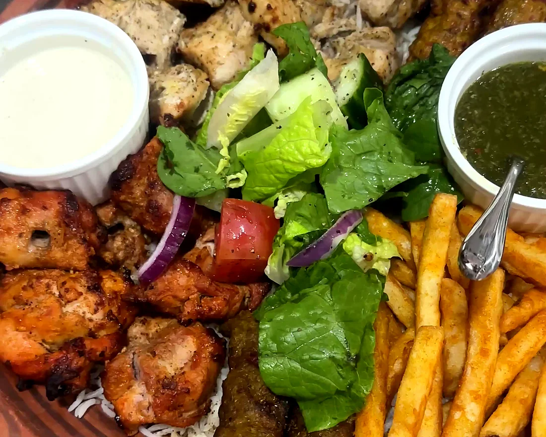 BBQ platter with malai tikka, chicken tikka and kabab, green salad, fries, raita and green chutney